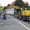 Mithilfe eines Baggers werden zunächst nicht mehr benötigte Gegenstände vom Bahnsteig entfernt.