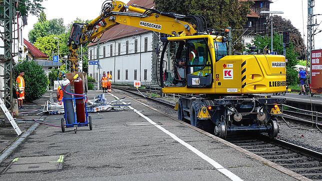 Mithilfe eines Baggers werden zunächst nicht mehr benötigte Gegenstände vom Bahnsteig entfernt.