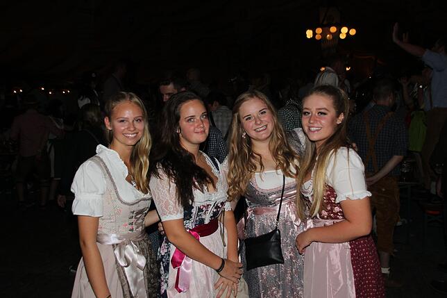 Diese Gruppe junger Frauen steht zu bayerischer Tracht mit Dirndl.