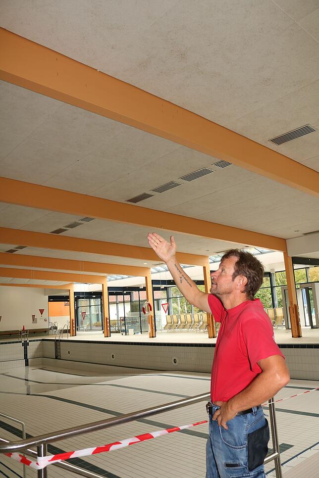 Betriebsleiter Michael Scholz zeigt auf die Trägerbalken in der Schwimmhalle.