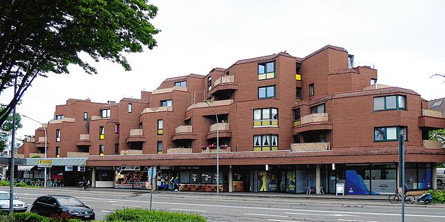 An der Wollmatinger Straße ein brauner Block mit kleinen Studentenwohnungen, einigen Kneipen, Sportbar und Spielhalle.