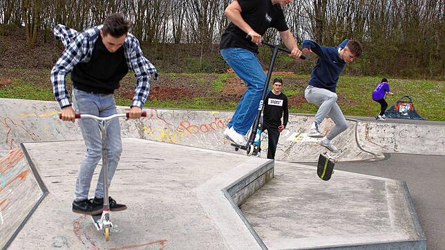 Jugendliche trainieren mit Scootern und Skateboards auf der Trendsportanlage, das Foto wurde vor der Corona-Krise gemacht. Trotz ...