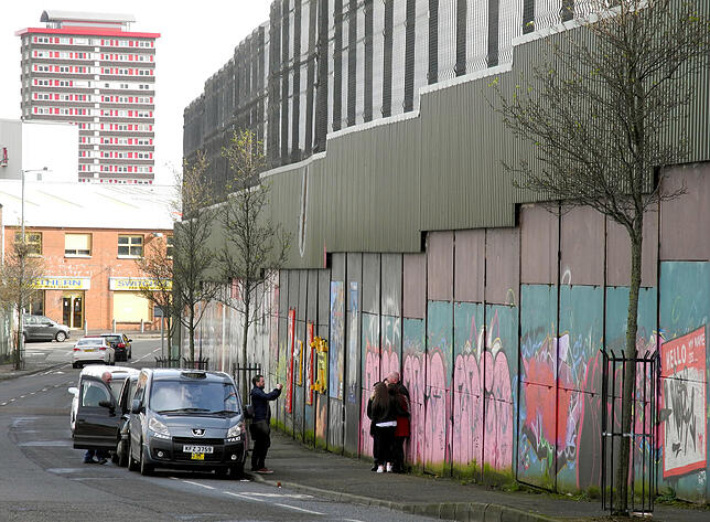 Touristen posieren vor der sogenannten Peace-Line in Belfast. Die Mauer trennt protestantische von katholischen Vierteln der Stadt.