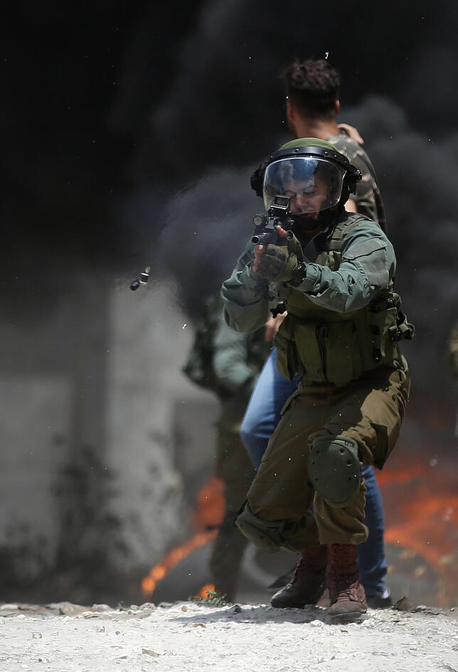 Ein israelischer Soldat zielt mit seiner Waffe bei Zusammenstößen mit palästinensischen Demonstranten.