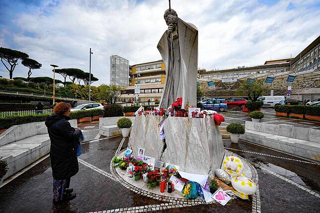 Eine Frau betet für Papst Franziskus vor der Poliklinik Agostino Gemelli in Rom, wo der Papst im Februar 2025 im Krankenhaus lag.