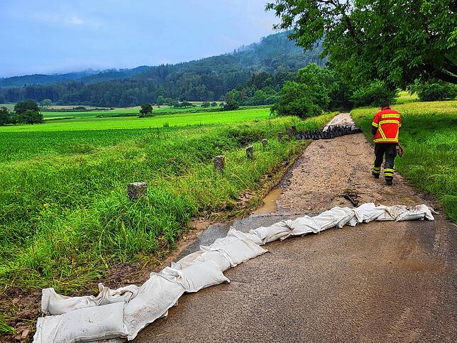 Mit Sandsäcken wurde der Wasserstrom in den ursprünglichen Bach umgeleitet. Erst dann war das Hochwasser gebannt.