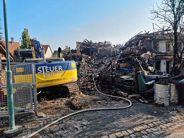 Der große Bagger trägt bis nach Mitternacht einen Teil des Gebäudes ab, damit die Feuerwehr an alle Glutnester herankommt.