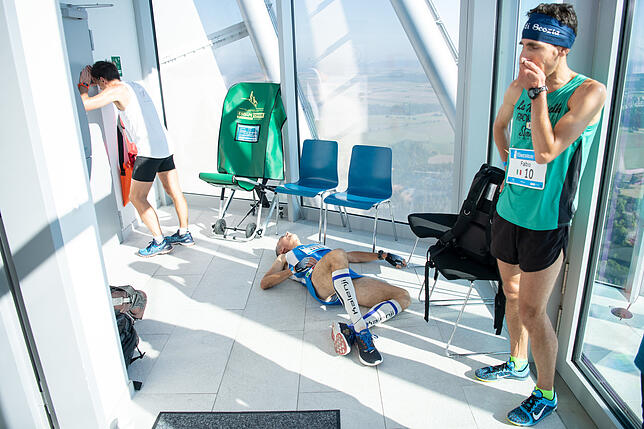 Läufer stehen und liegen erschöpft nach dem Towerrun im Rottweiler Testturm von ThyssenKrupp auf der Aussichtsplattform, rechts steht ...