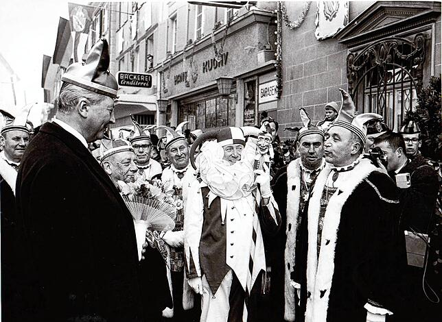 Empfang am Schmutzigen Donnerstag, 25. Februar 1965, vor dem Rathaus in der Hauptstraße. Von links: Gerichtsnarr Heinrich Schappeler, ...