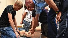 Polizist Henry Limp zeigt Damian Gayt (links) und Luca Johnen, wie sie einen Menschen reanimieren können. Zur Berufsorientierung konnten ...