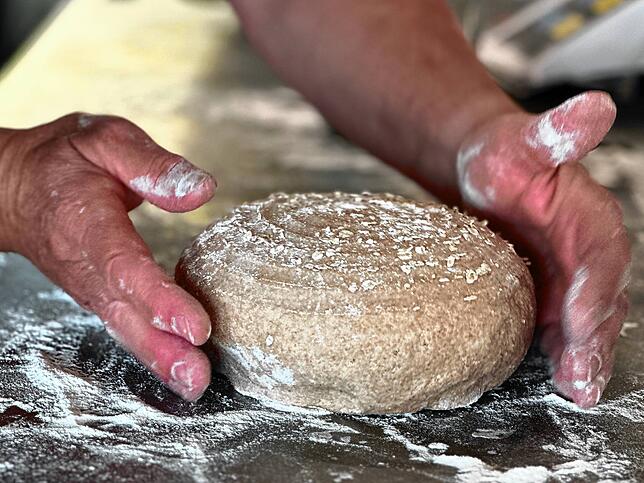 Mit schnellen Handbewegungen gibt Ulrike Münch auf dem Breghof in Bruggen den Vollkorn-Emmerbroten den letzten Schliff.