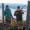 Mit ihren Booten bringen Mitglieder des Angelsportvereins – hier Kay Drechsler und Peter Boos – das Gehölz zum Fischreiser.