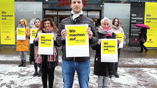 Die Abteilungsleiterinnen und der Geschäftsführer von Mode Zinser in Singen wollen mit einer Plakataktion in den Schaufenstern auf die ...