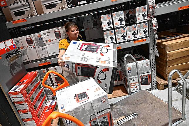 Experten raten ab, doch die Nachfrage ist groß: Eine Baumarkt-Mitarbeiterin räumt Heizlüfter sein.