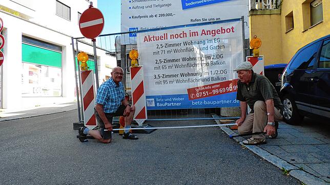 Die Baustellennachbarn Karl Dorn (links) und Egon Drössel messen nach: Rund drei Meter nimmt der Bauzaun um den Wohnwagen von der ...