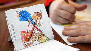 Eine Kinderzeichnung in einem Heft, welches die Aufforderung „Nicht schlagen“ darstellt. (Symbolfoto) Regeln und Routinen sind in der ...