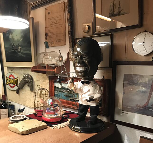 Als Schmidt sich die Figur des schwarzen Barkeepers auf die Theke stellte, galt das noch als netter Gag. Im Hintergrund ein Buddelschiff ...