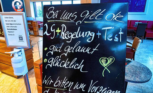 Ein Schild , das auf die 2G-Plus-Regel hinweist, steht vor einem Eiscafé. In immer mehr Kommunen wird der Eintritt für Ungeimpfte ...