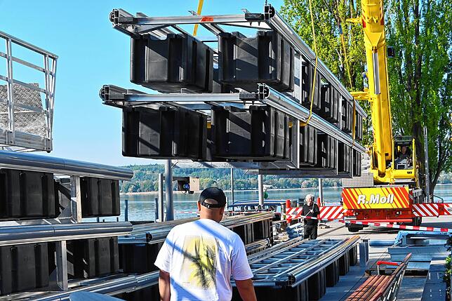 Die neuen Steg-Elemente werden abgeladen, um die Schutzrahmen aus Aluminium montieren zu können.