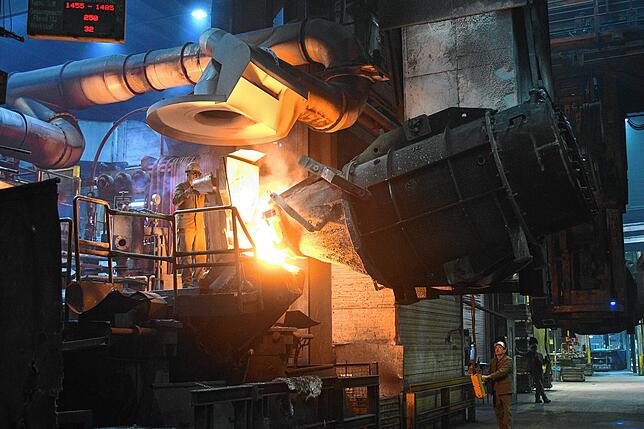 Schwerindustrie in Singen: Flüssiges Eisen fließt aus einem Konverter ab zur Weiterverarbeitung.