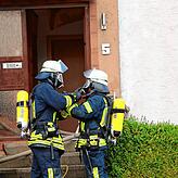 Feuerwehrleute bereiten sich auf den Einsatz im Gebäude vor.