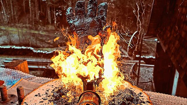 Mit einer Flamme wird ein geteerter Handschuh bearbeitet. Bild: Scherzinger