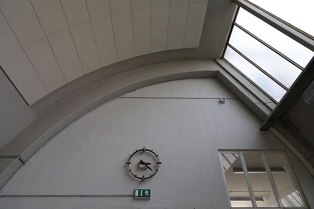 Die Uhr an der Schmalseite eines Hallen-Abschnitts könnte aus Der Zeit der Erbauung stammen, und sie läuft noch immer. Man kann sie von ...