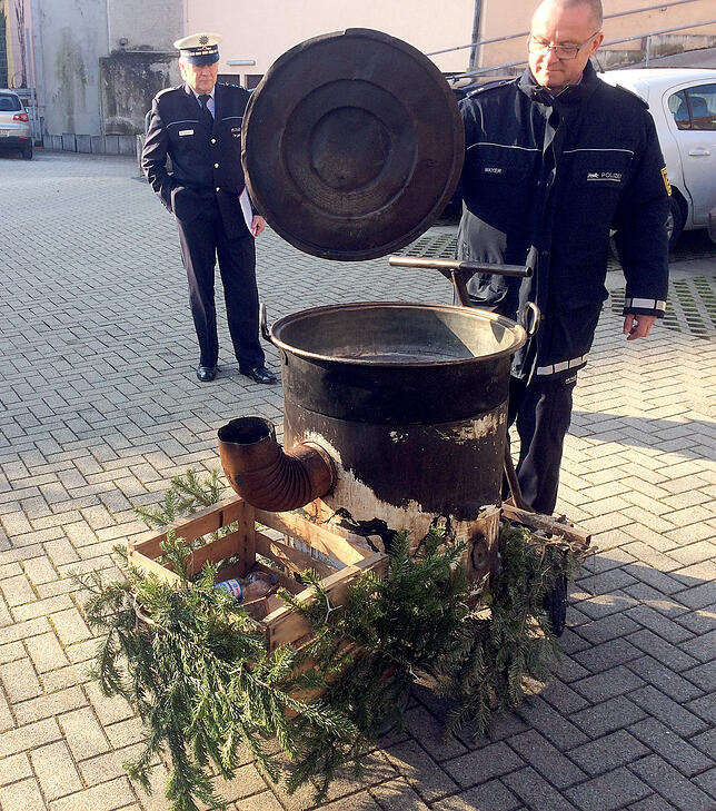 Zuschauerin verbrüht sich in Hexenkessel Polizisten stehen vor der Polizeiwache an einem Kessel, in dem sich bei einem Fastnachtsumzug eine junge Frau mit heißem Wasser an den ...