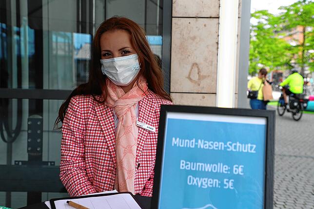 Agnes Grießhaber verkauft am Stand vor dem Lago Mund-Nasen-Schutzmasken.