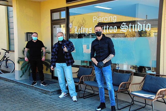 Die Tätowierer Decusara Florin (links) und Bes Ademaj (rechts), in der Mitte Inhaber und Geschäftsführer Alexander Lefty Schmalenberger.