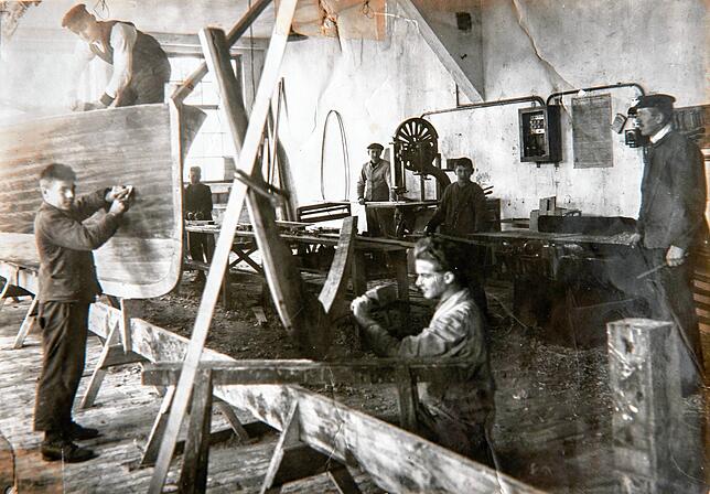Bootsbauer in der Michelsen-Werft der 20er-Jahre, rechts Meister Heinrich Michelsen.