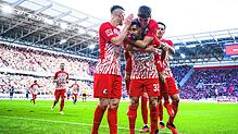 Vincenzo Grifo hat nach seinem Tor zum 2:1 Noah Weißhaupt geschultert, Roland Sallai (links) und Nicolas Höfler (rechts) gratulieren ...