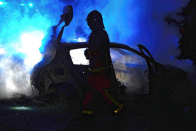 Ein Feuerwehrmann bei einem brennenden Auto in Nanterre