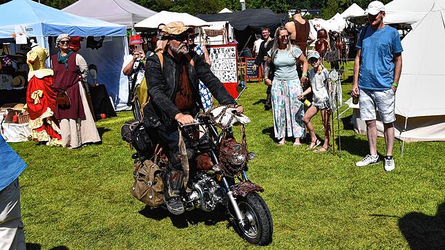 Ob der Motorradfahrer aus der Endzeit wohl im Zeitreisebüro der Steampunker war? Denn hier fährt er bei „Das große Treffen“ in Aach über ...