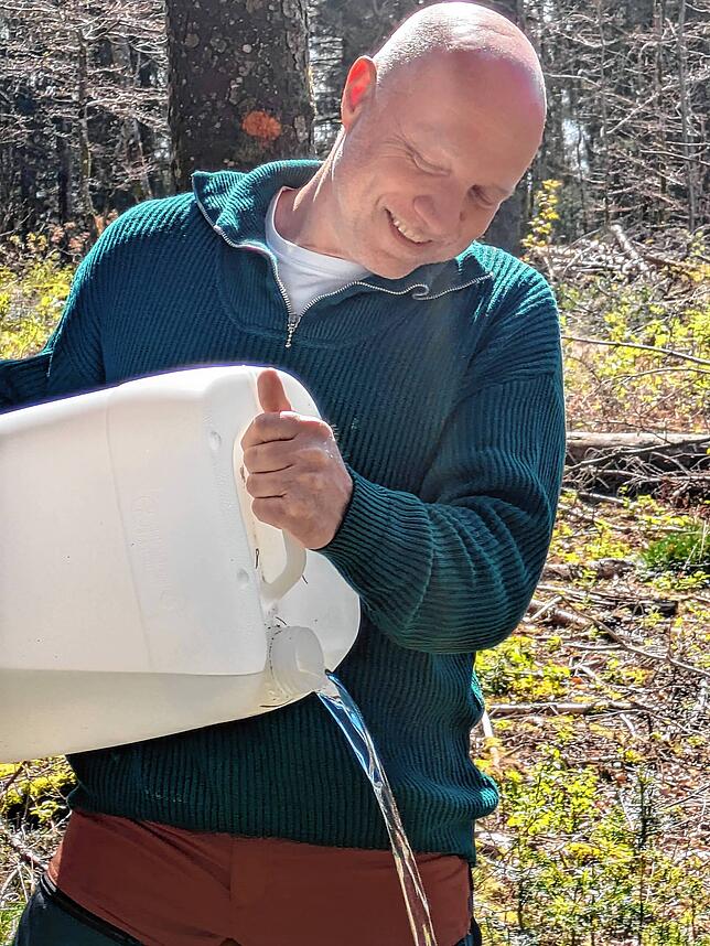 Der Fröhnder Bürgermeister Michael Engesser misst die Wasserausbeute.