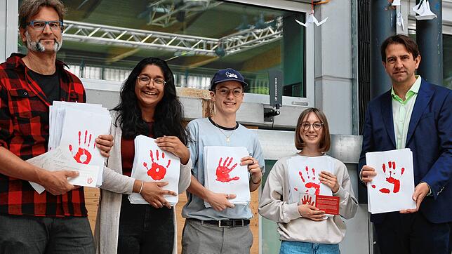 Während des Besuchs des Bundestagsabgeordneten Andreas Jung (rechts) zum Tag des Grundgesetzes wurden ihm 577 rote Handabdrücke gegen ...