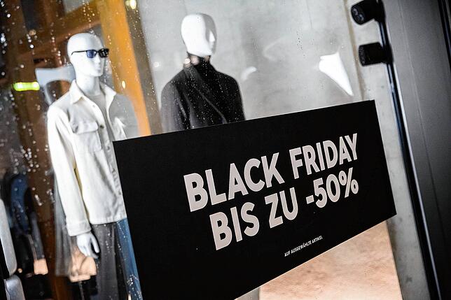Ein Plakat zum Black Friday ist im Schaufenster eines Bekleidungsgeschäftes am Kurfürstendamm in Berlin zu sehen.