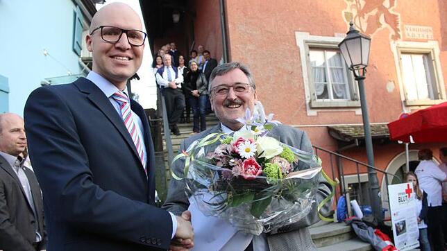 Blumen für den neuen Sipplinger Bürgermeister am Wahlabend: Anselm Neher gratuliert seinem Amtsnachfolger Oliver Gortat. Bild: Stefan Hilser