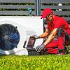 Ein Monteur installiert eine Wärmepumpe in einem Garten. Aber für welche Art von Häusern taugt das System eigentlich?