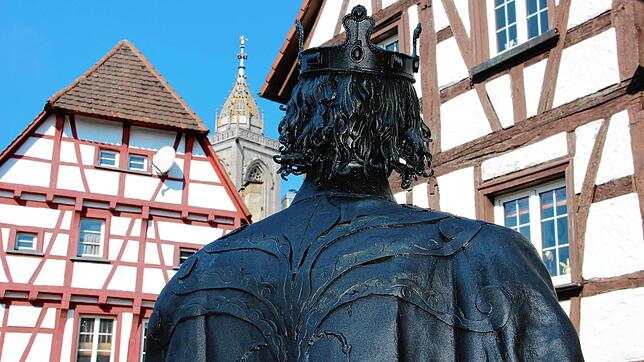 Beim Blick über die Schulter des Stauferkönigs Friedrich II sieht man den Glockenturm der Stadtkirche St. Jakobus zwischen den ...