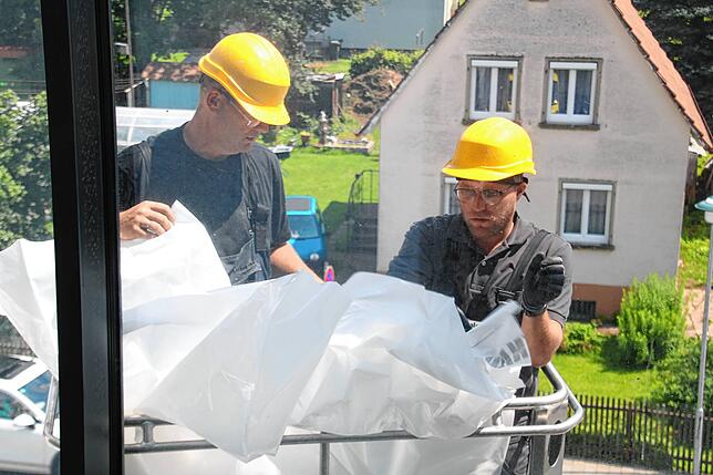 Nehmen erste Aufräumarbeiten vor und bringen einen Wetterschutz am ramponierten Gebäude in Blumberg an: Jochen Schlenker (links) und ...