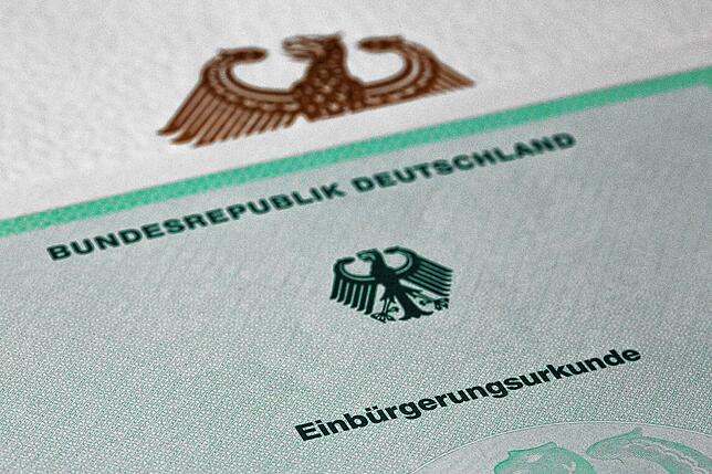 Eine Einbürgerungsurkunde der Bundesrepublik Deutschland liegt auf einem Tisch.