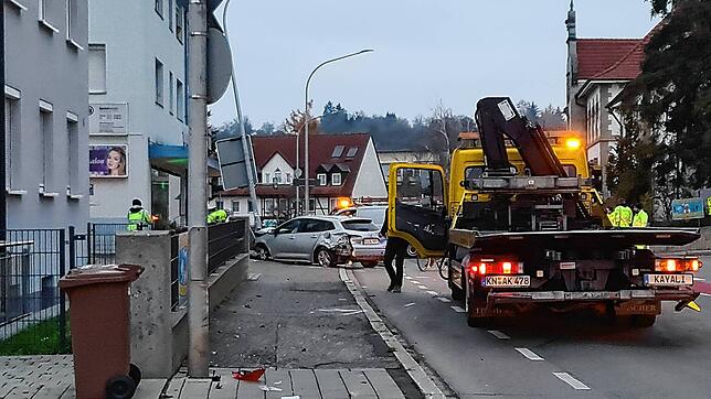 Der Unfallwagen (hinten) wird abgeschleppt. Im Vordergrund sind Trümmerteile zu erkennen.