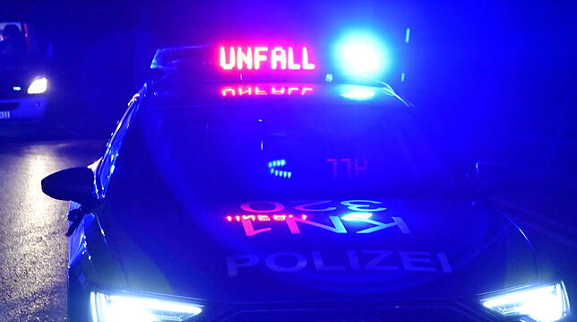 Ein Polizeifahrzeug mit Unfall-Schriftzug und Blaulicht warnt andere Autofahrer.