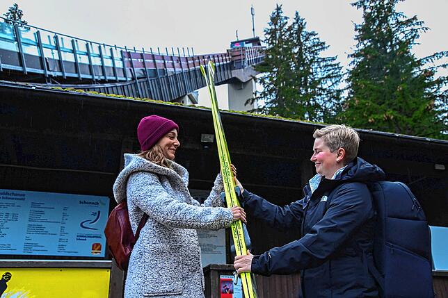 Um ein Gefühl dafür zu bekommen, wie es ist, die langen Skier die vielen Stufen hinaufzutragen, drückt Benita Hansmann (rechts) ...