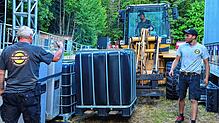 Millimeterarbeit leisten hier Bernd Höfler (links), Matthias Moosmann und David Moosmann (im Radlader), um das Bühnenequipment präzise ...