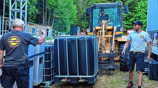 Millimeterarbeit leisten hier Bernd Höfler (links), Matthias Moosmann und David Moosmann (im Radlader), um das Bühnenequipment präzise ...