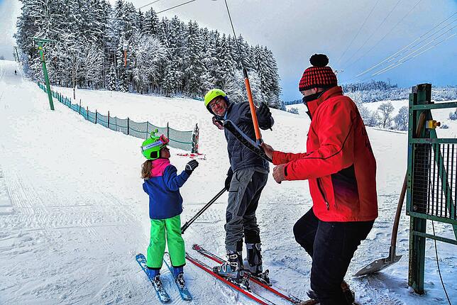 Ewald Bähr reicht Harald Haberer und dessen Tochter Nina den Liftbügel. Die Familie aus Grüningen kann sich eine Stunde ganz für sich ...