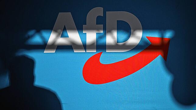 Ein Redner wirft einen Schatten auf die Bühnenrückwand mit AfD-Schriftzug auf einer Veranstaltung. Eine Bühnenwand zeigt das Logo der ...