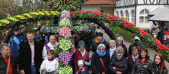 Unter dem rechten Bogen des Markelfinger Osterbrunnen stehen die Menschen, die in den Wochen zuvor die Bögen, Kränze und Krone mit ...